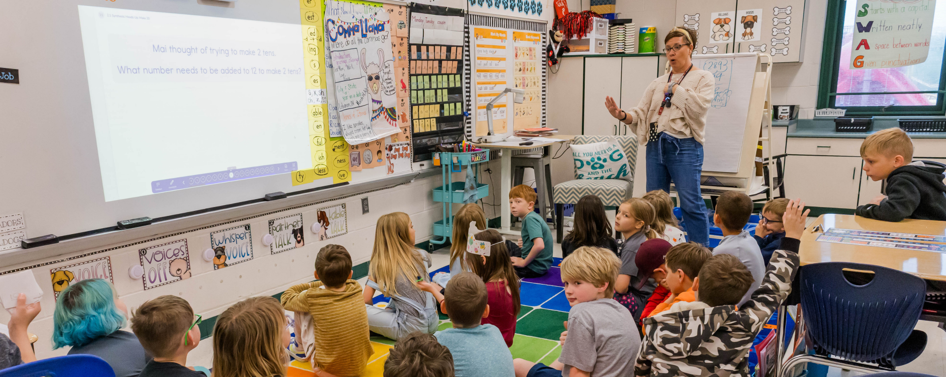 students in a classroom in front of a whiteboard 