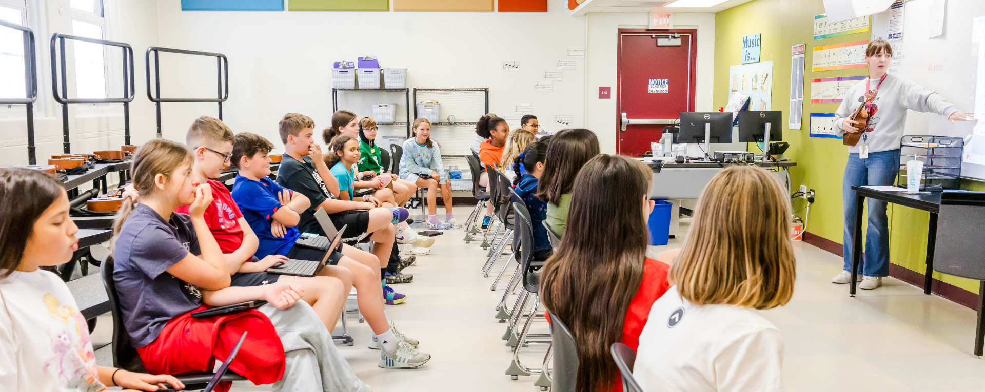 students in a music class facing the teacher