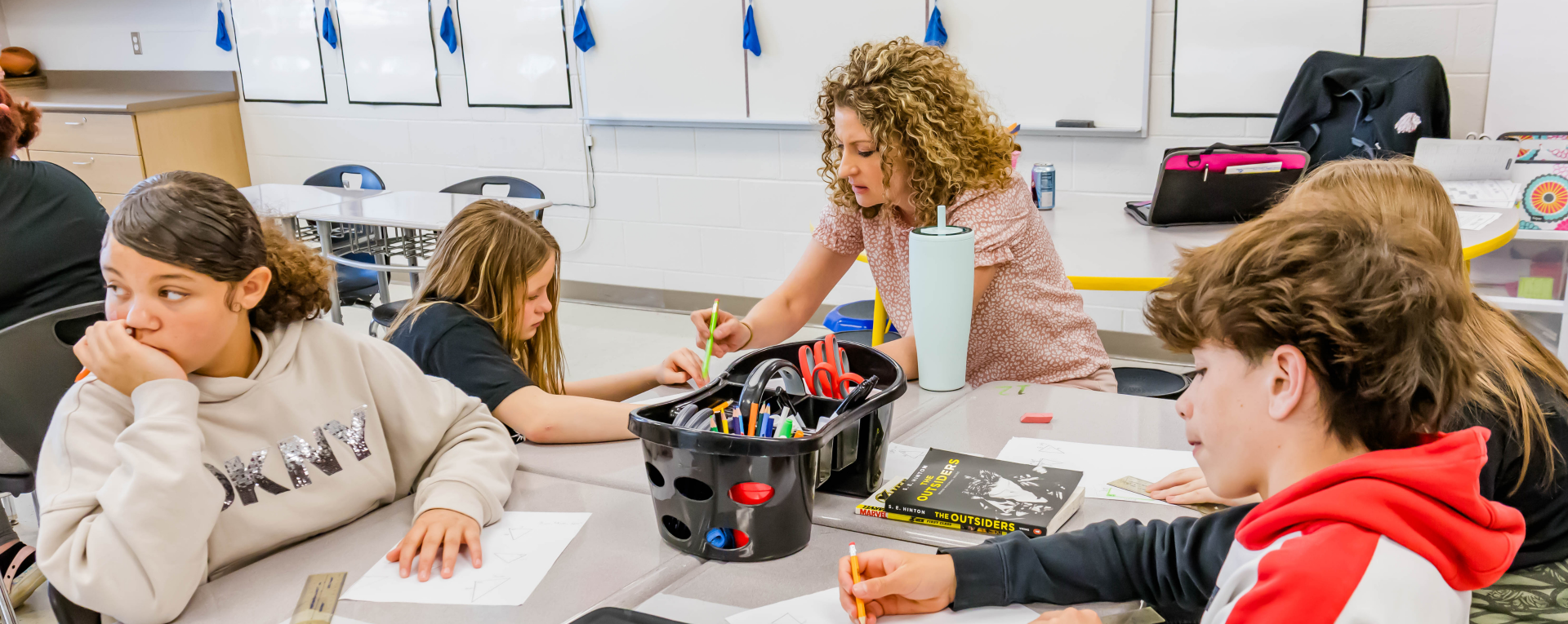 students at a table working with a teacher